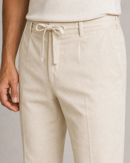 Men's beige summer pants, drawstring waistband and pocket construction detail.